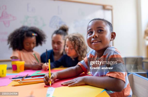 scolaro felice che disegna in classe all'asilo - bambino di età prescolare foto e immagini stock