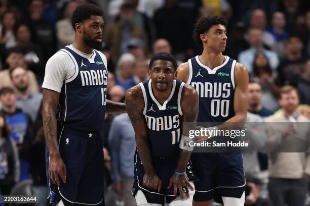 Naji Marshall, Kyrie Irving and Max Christie of the Dallas Mavericks pause during the first half against the Sacramento Kings at American Airlines...