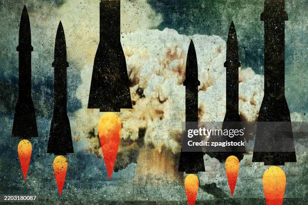 nuclear threat: silhouetted missiles against atomic explosion - arma nuclear fotografías e imágenes de stock