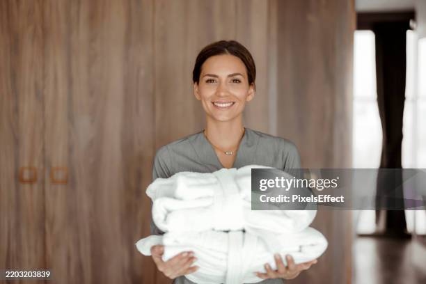 hospitality in focus: cameriera in posa in una camera d'albergo chic - servizio in camera foto e immagini stock