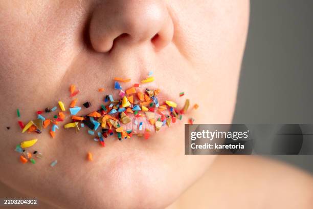 close-up of woman lower face with microplastic on lips - mikroplastik stock-fotos und bilder