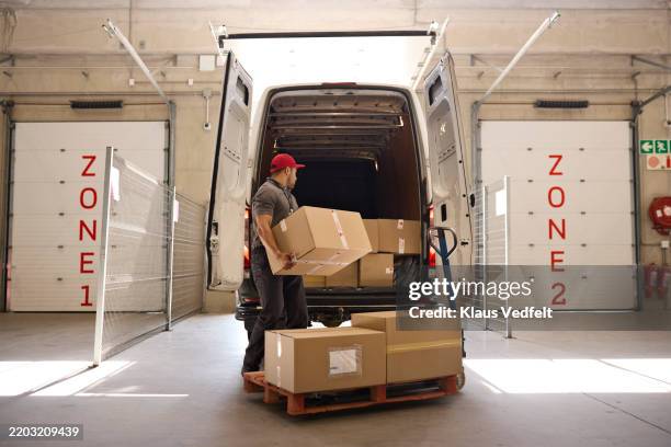 worker carrying cardboard box while loading in van - open van stock pictures, royalty-free photos & images