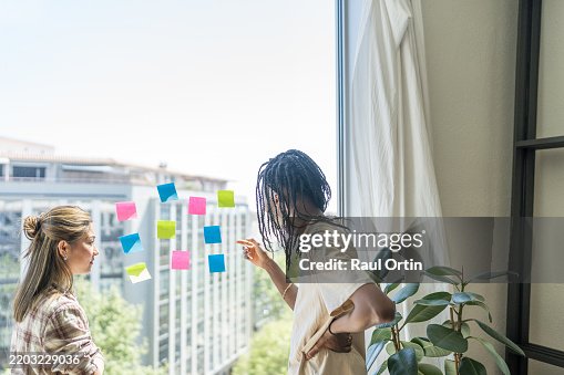 Window Paning Notes Two Young Businesswomen Planning Strategy Using Sticky Notes On A ...