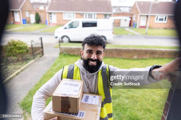 delivery driver at smart doorbell - postal worker stock pictures, royalty-free photos & images