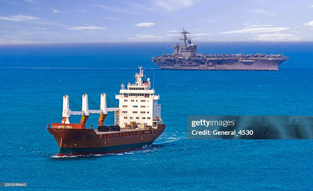 Aerial view container ship and aircraft carrier at sea.