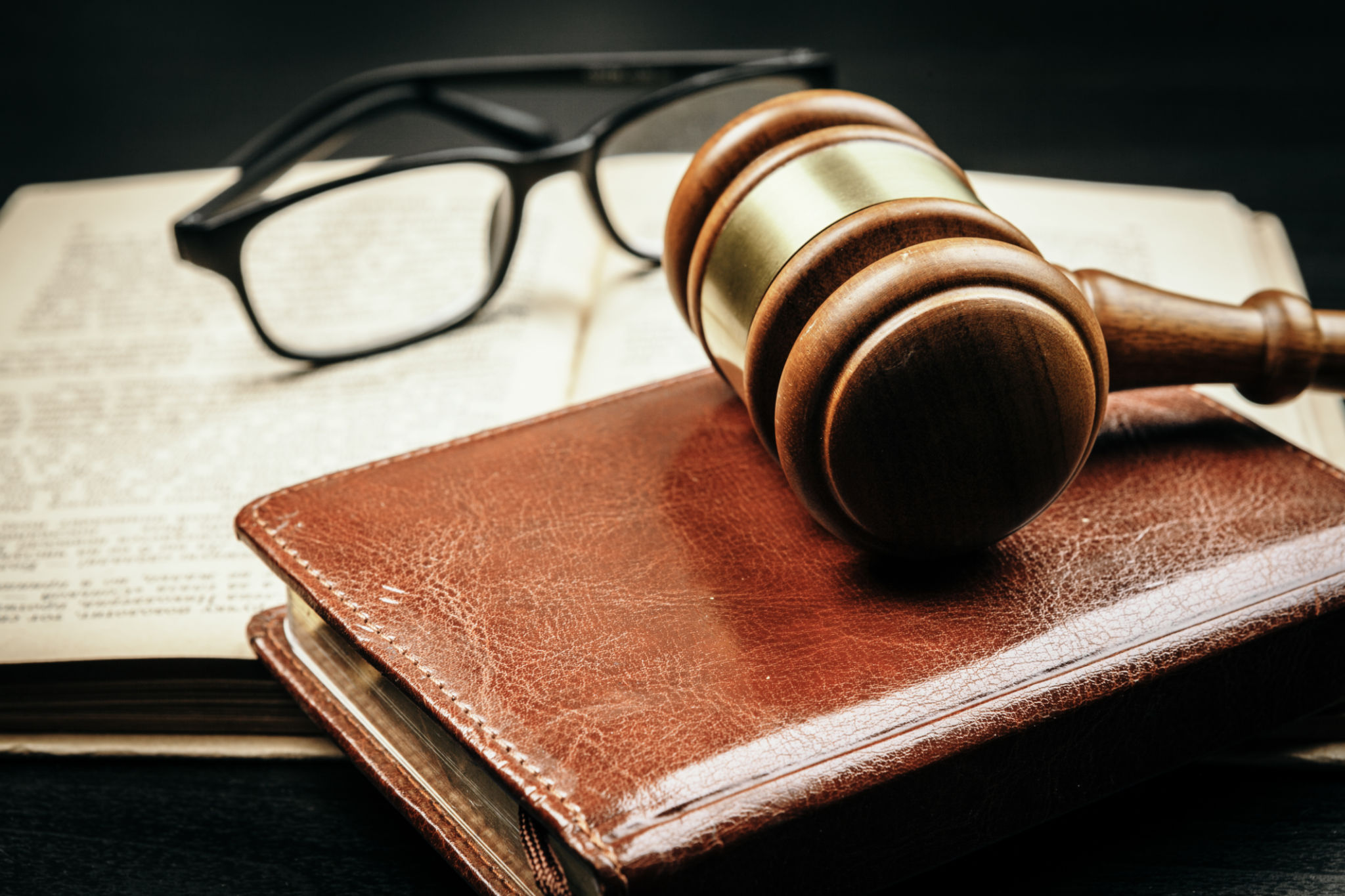 Brown wooden judge mallet on the background of open book Brown wooden judge mallet on the background of open book