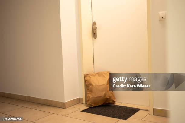 parcel home delivery. the delivery man left the parcel near front door. delivered package near apartment door. - umbral fotografías e imágenes de stock