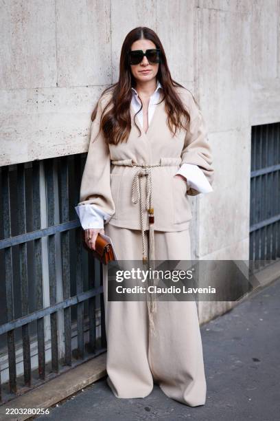 Alessandra Airo wears white shirt, cream jacket with matching pants, brown bag, black sunglasses, outside Max Mara, during the Milan Fashion Week...