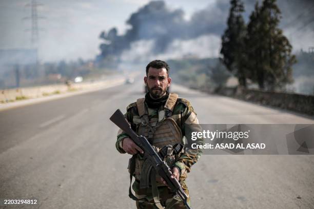 Syrian fighter looks into to the camera as the new Syrian government's army fights the remaining elements of the Assad's regime on the Syrian coast...
