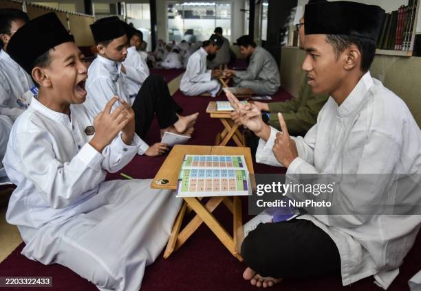 Deaf child learns to read the Quran from a teacher using the sign method during Ramadan at Al Madinah Mosque in Malang, East Java, Indonesia, on...