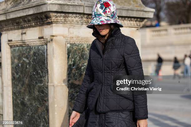 Guest wears bucket hat with print, quilted jacket outside Dior during the Womenswear Fall/Winter 2025/2026 as part of Paris Fashion Week on March 04,...