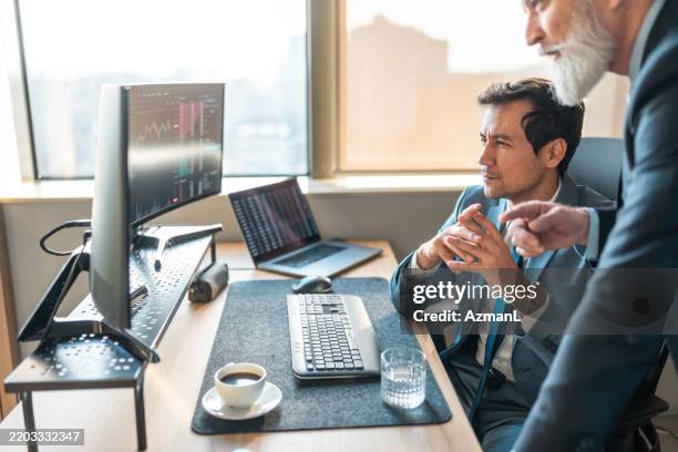 focused stock brokers analyzing data in modern office - stock broker office stock pictures, royalty-free photos & images