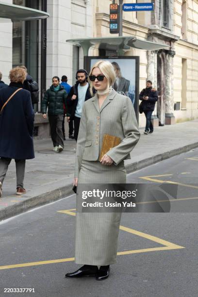 Guest wears a grey suit, black glasses, a brown bag and black shoes outside Magda Butrym during the Womenswear Fall/Winter 2025/2026 as part of Paris...