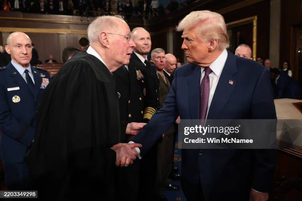 President Donald Trump shakes hands with retired Supreme Court Justice Anthony Kennedy after addressing a joint session of Congress at the U.S....