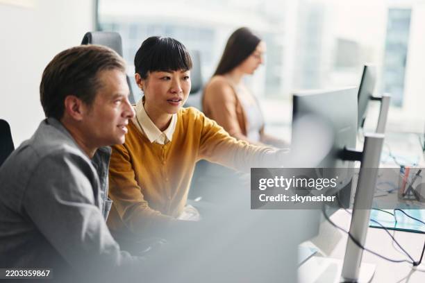 mid adult programmers reading codes on desktop pc in the office. - roupa descontraída imagens e fotografias de stock