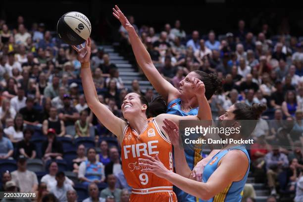 Alicia Froling of the Fire shoots under pressure from Kelsey Griffin of the Spirit and Marianna Tolo of the Spirit during game one of the WNBL Grand...