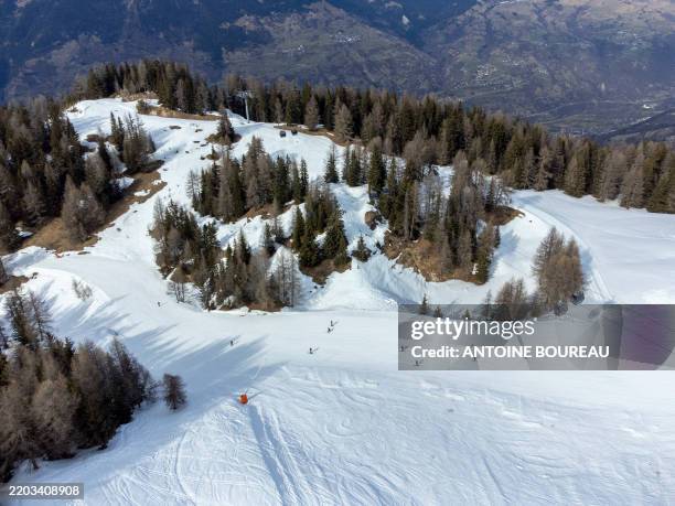Aerial view made using a drone of an artificial snow landscape due to climate change at the La Plagne ski resort at the place called Le Fornelet...