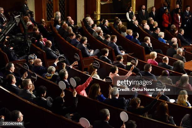 House Democrats hold signs in protest during a joint session of Congress in the House Chamber of the US Capitol on March 4, 2025 in Washington, DC....