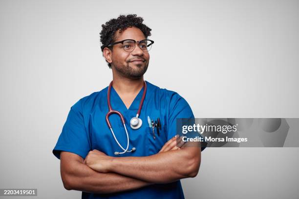 confident african american male nurse against white background - medizinerkleidung stock-fotos und bilder