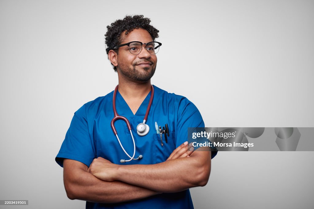 Confident African American Male Nurse Against White Background
