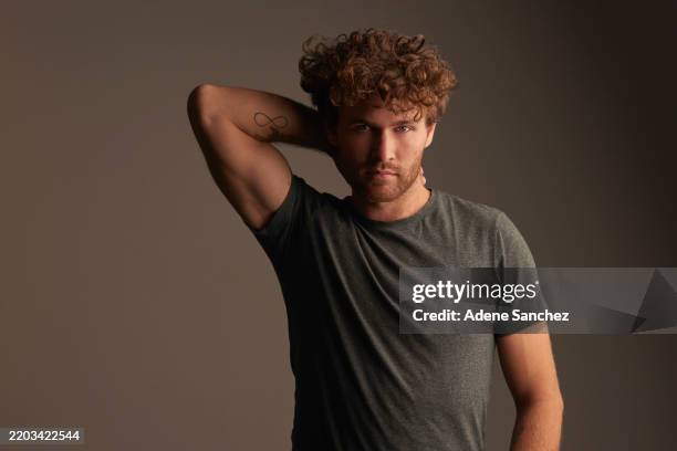 portrait, fashion and confident with a handsome man posing in studio on a gray background for trendy style. casual, bicep and brooding with a young male model standing in a contemporary clothes brand - sulking stock pictures, royalty-free photos & images