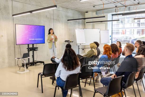 businesswoman addressing business professionals at a corporate seminar - compere stock pictures, royalty-free photos & images