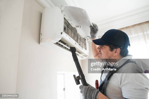 technician clearing air conditioner - indoor air pollution stock pictures, royalty-free photos & images