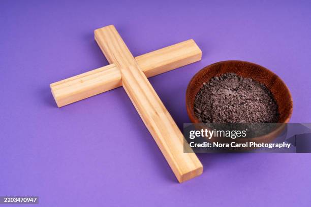 ashes and christianity cross on purple background - holy saturday stock pictures, royalty-free photos & images