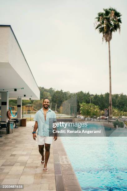 mature man walking by the pool - funny gay man stock pictures, royalty-free photos & images