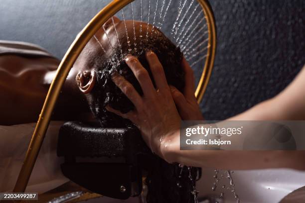 sie lehnt sich zurück und lässt sich unter einem strahl warmen wassers sanft auf die kopfhaut einmassieren. - kopf an kopf stock-fotos und bilder