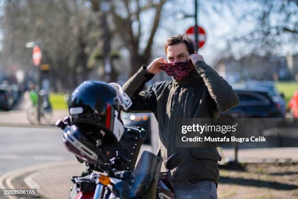 male rider young adult next to motorcycle - neck gaiter stock pictures, royalty-free photos & images