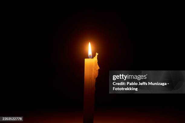 burning candle illuminating the darkness with its warm glow - apagão imagens e fotografias de stock