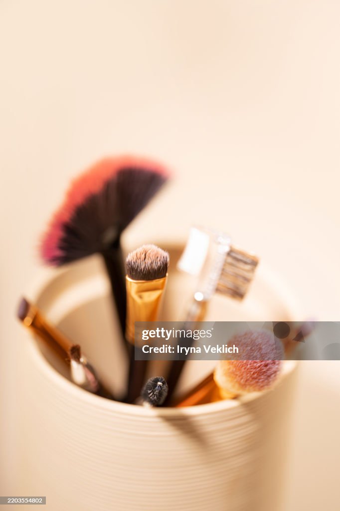 Set of Multi-functional Makeup Brush on pastel beige pink color background.