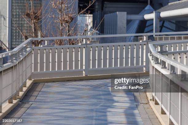 empty pedestrian bridge in modern city in osaka, japan - footbridge stock pictures, royalty-free photos & images