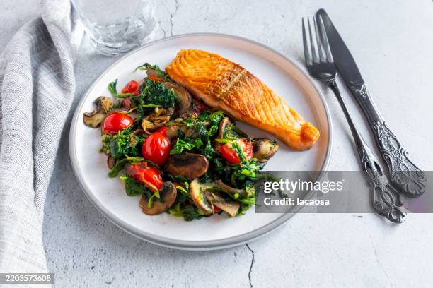 grilled salmon with spinach, mushrooms and tomatoes - régime faible en glucides photos et images de collection