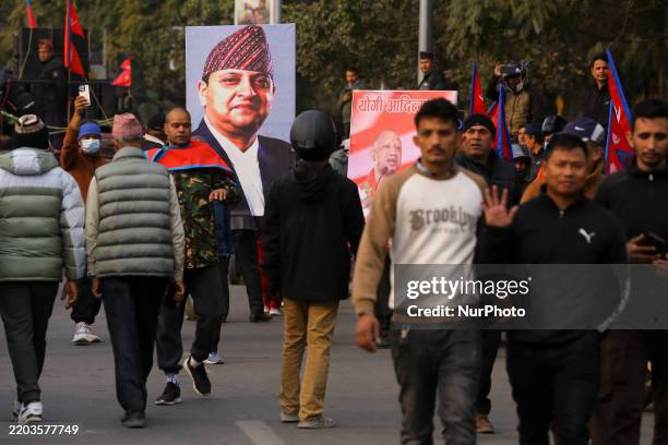 Pro-monarchists hold photos of former King Gyanendra Bir Bikram Shah and Yogi Aditya Nath, CM of India's Uttar Pradesh, as they gather outside...