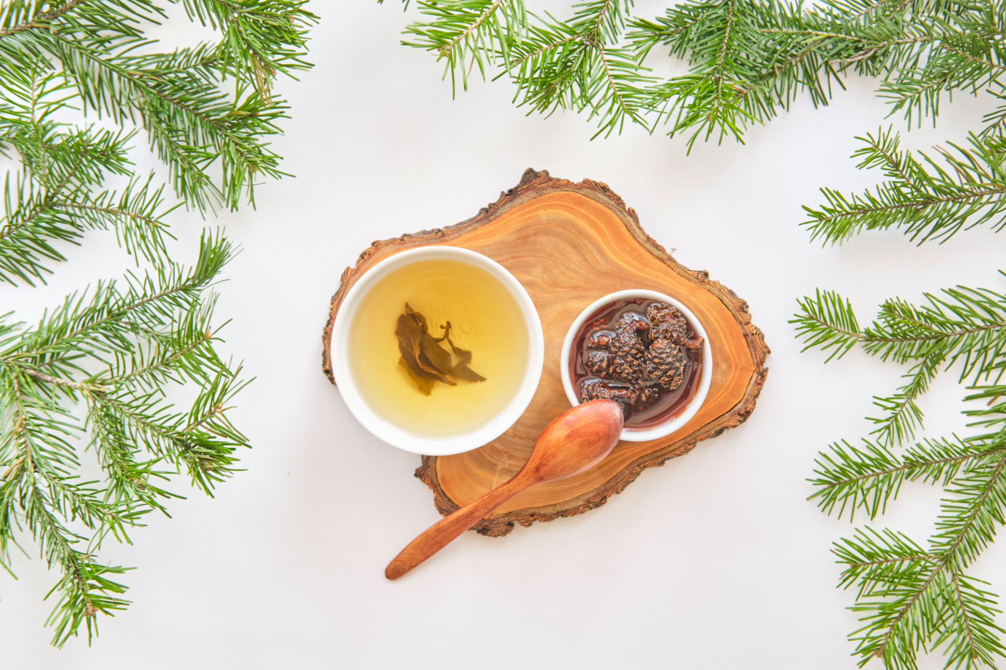 Herbal tea and pine cone jam on wooden board with fir branches Herbal tea and pine cone jam on wooden board with fir branches