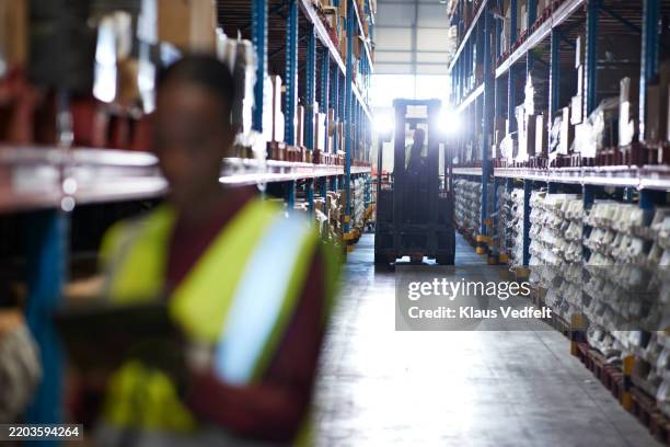 worker driving forklift in warehouse - supply and demand stock pictures, royalty-free photos & images