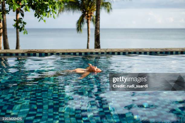 man floating on pool and enjoying the vacation on sunny day. - epic moment stock pictures, royalty-free photos & images
