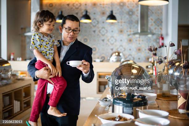 affectionate single father and his small son during meal breakfast at the hotel buffet - key worker stock pictures, royalty-free photos & images