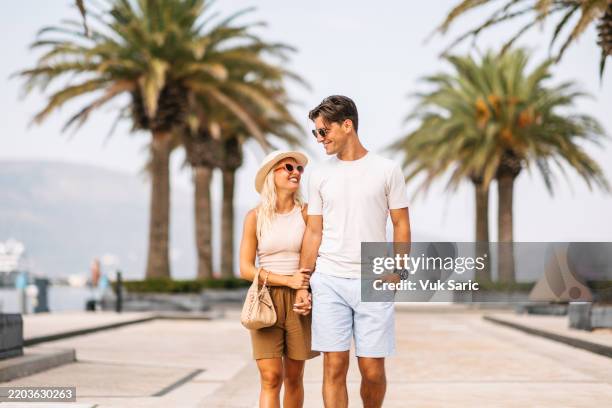 couple walking by tropical port - well dressed stock pictures, royalty-free photos & images