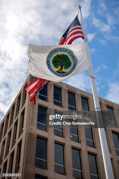 The U.S. Flag and Department of Education flags whip in the wind outside the department's headquarters on March 06, 2025 in Washington, DC. U.S....