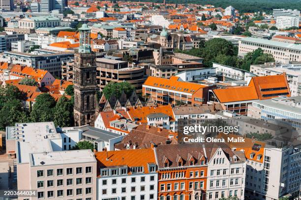 aerial view of urban cityscape with a church and orange rooftops in hannover, germany - hannover fotografías e imágenes de stock