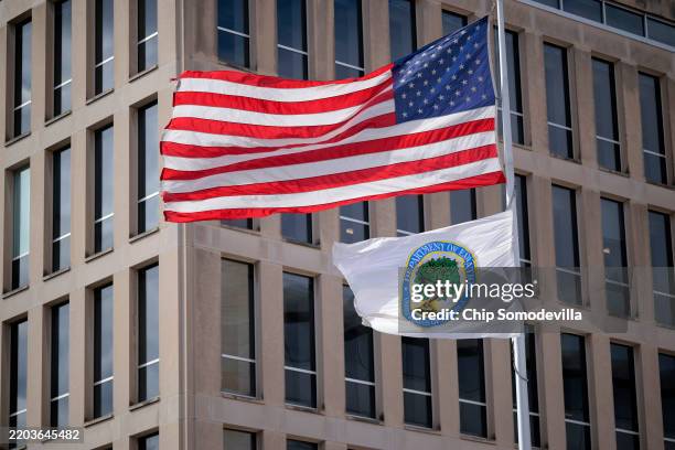 The U.S. Flag and Department of Education flags whip in the wind outside the department's headquarters on March 06, 2025 in Washington, DC. U.S....