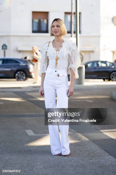 Maria Olympia of Greece and Denmark wears a gold necklace, a white lace puffy sleeves shirt, beige heels, white high waist flared trousers and a gold...