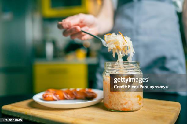 close-up of a fork with sauerkraut and a piece of bavarian sausage - i was turning into a vegetable stock pictures, royalty-free photos & images