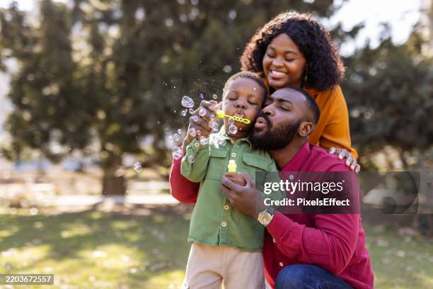 magical moments: a family’s bubble blowing fun - afroamerikanskt ursprung bildbanksfoton och bilder