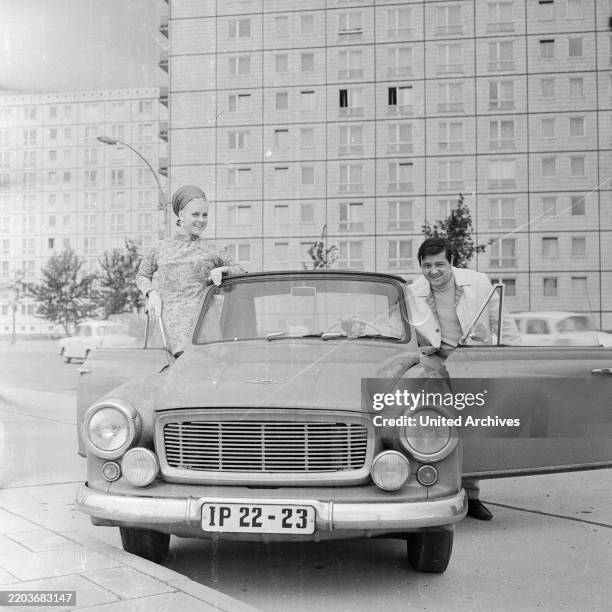 Thomas Lück, deutscher Schlagersänger, mit Gesangspartnerin und Trabant bei einem Werbefotoshoot vor einer Plattenbausiedlung in Ost Berlin, DDR 1968.