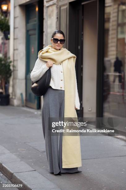 Gili Biegun wears grey pants, white knitted top with long sleeves, and pale yellow long wide scarf, balck leather bag and sunglasses during the...