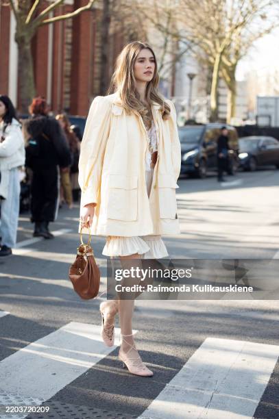 Zita D'hauteville wears white lace top, cream ruffled shorts, light yellow jacket, brown Chloé bag, outside the Chloe fashion show during the...